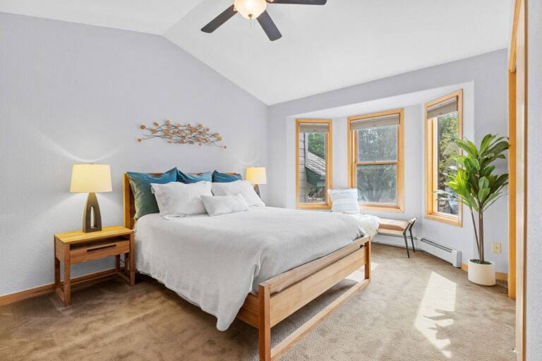 Primary bedroom with grey walls and white bedding